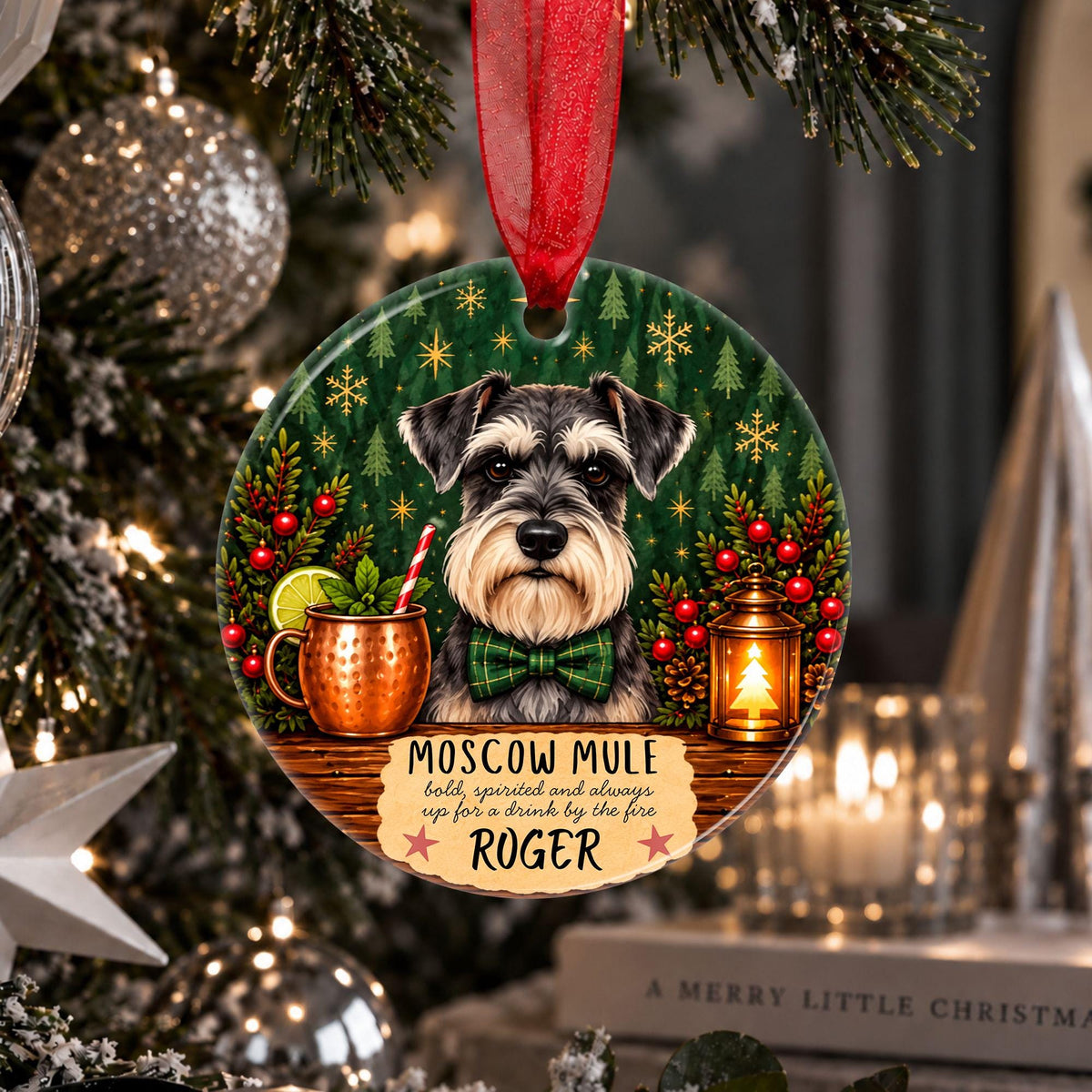 A personalized round Christmas ornament hanging on a decorated Christmas tree. The ornament features a portrait of a Schnauzer dog wearing a green bow tie, with a copper mug, a lantern, and the text 'MOSCOW MULE holds, spirited and always up for a drink by the fire, ROGER'.