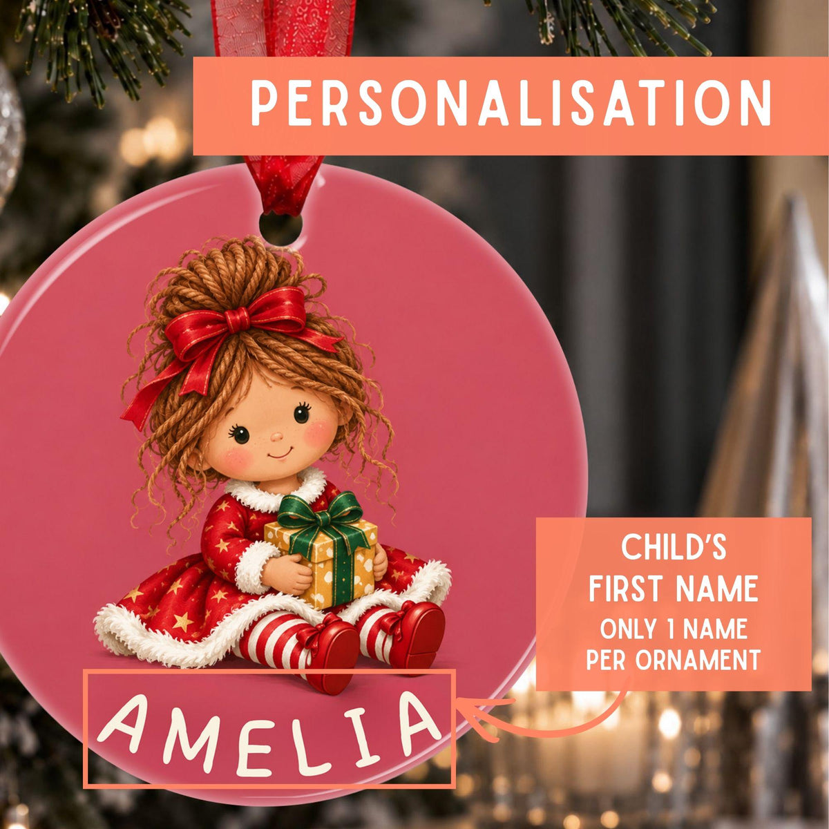 Personalized Christmas ornament featuring a cartoon girl in a red dress holding a gift, with the name 'AMELIA' and a red ribbon loop. The image includes promotional text overlays explaining the personalization option.