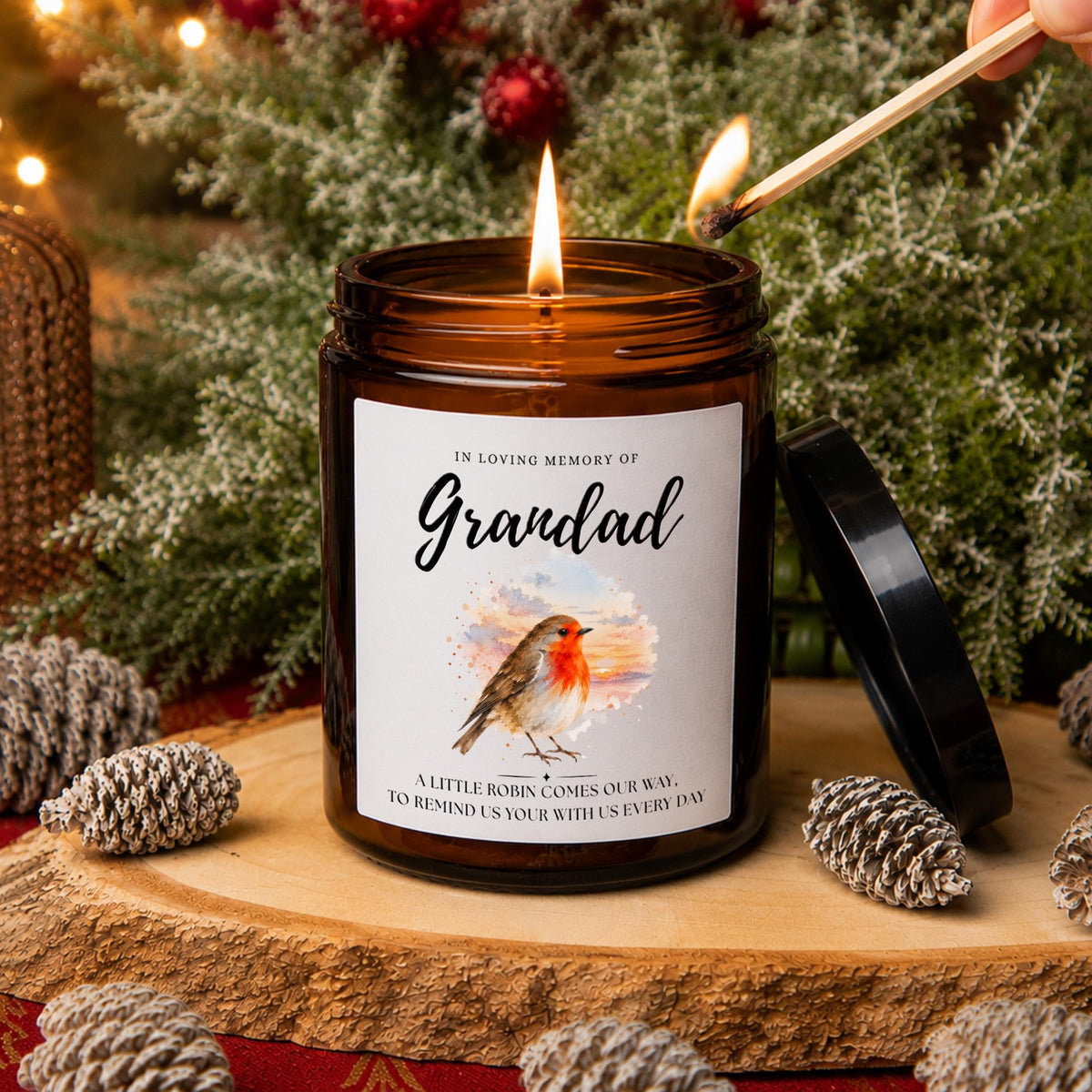 Personalised robin memorial apothecary candle in an amber glass jar, featuring a watercolour robin, Grandad remembrance message and festive greenery with pine cones.