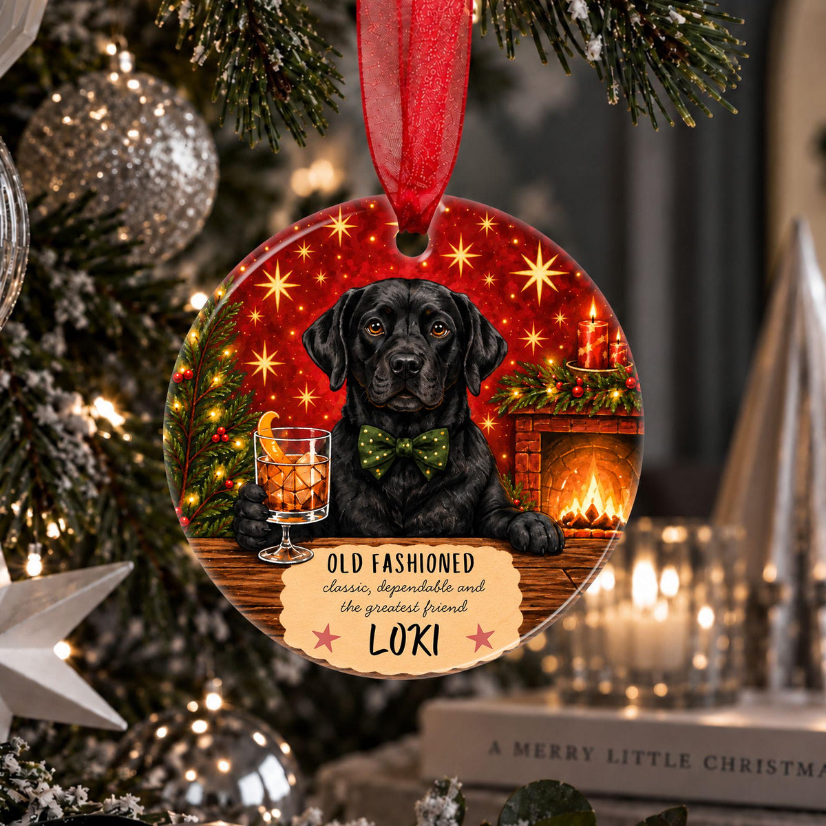 A personalized round Christmas ornament hanging on a decorated Christmas tree. The ornament features a black Labrador retriever wearing a green bow tie, sitting by a fireplace with a drink, set against a red starry background.