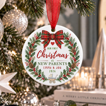 personalised new parents ceramic hanging tree decoration. Shown having from a christmas tree with a red ribbon.