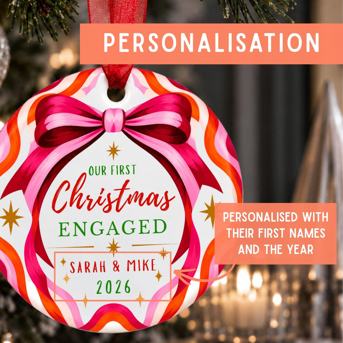 A personalized round Christmas ornament hanging on a decorated tree. The ornament has a white center with a pink bow illustration and red, pink, orange, and white wavy border.