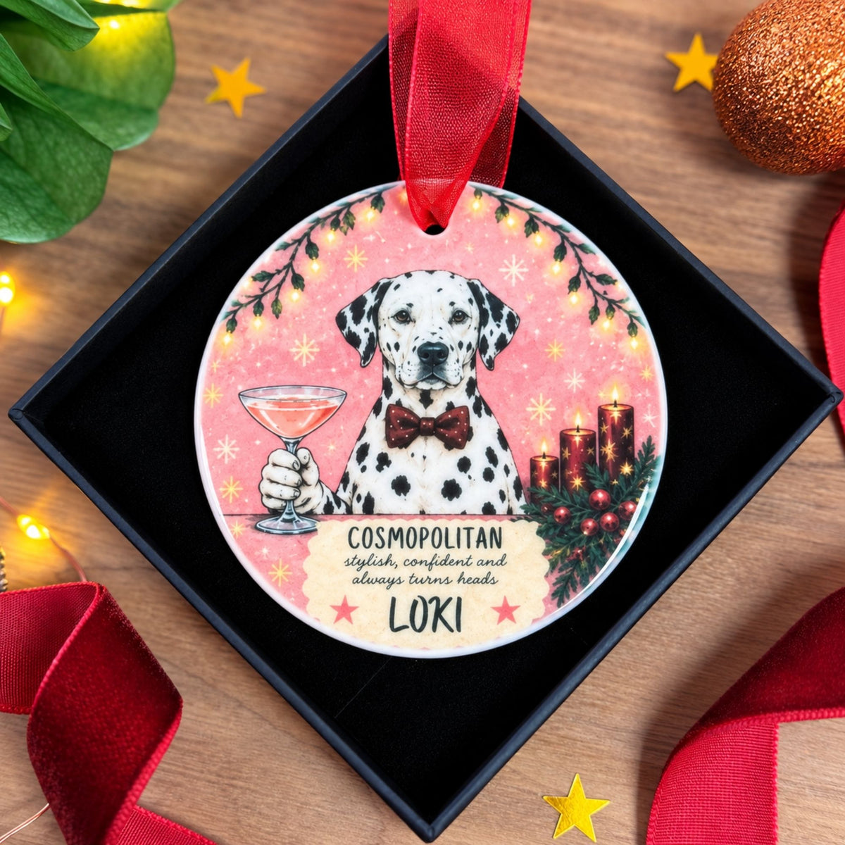 A personalized round Christmas ornament featuring a Dalmatian dog illustration, presented inside a black gift box on a wooden surface with festive decorations.