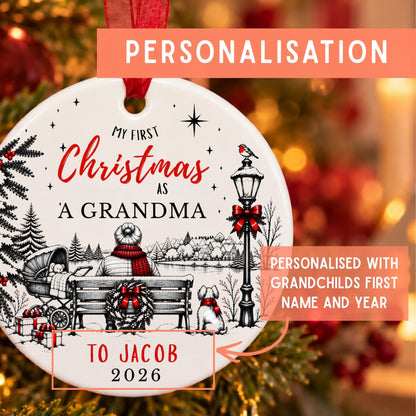 Personalized round Christmas ornament with a red ribbon hanger, featuring a black and white winter scene with red text reading 'My First Christmas As A Grandma' and 'To Jacob 2026'. The image includes orange promotional text overlays explaining personalization.
