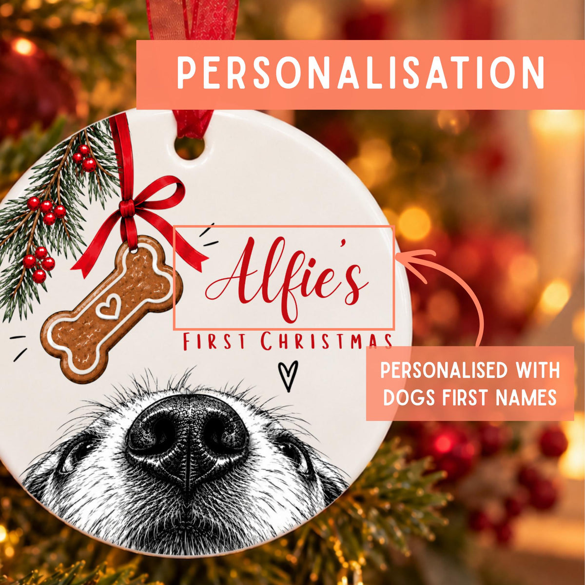 Personalized round ceramic Christmas ornament featuring a black-and-white dog face illustration, a red ribbon, a red bow, a gingerbread bone with a heart, pine branches with red berries, and the text 'Alfie's FIRST CHRISTMAS' and 'PERSONALISED WITH DOGS FIRST NAMES'.