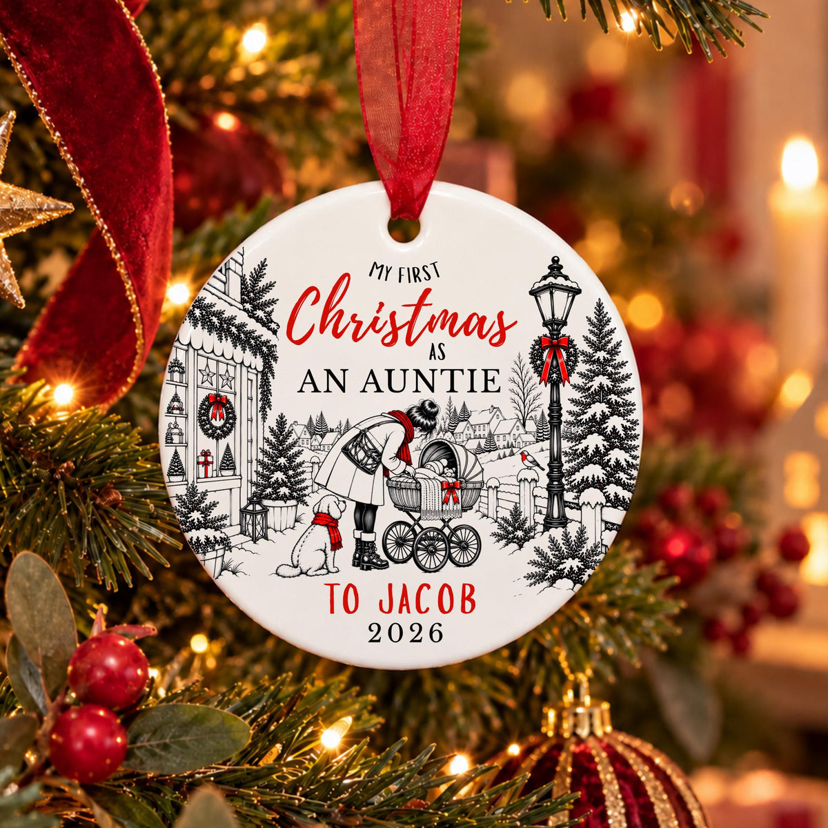 A personalized round Christmas ornament hanging on a decorated tree. The white ornament features a black line art illustration of a woman pushing a stroller with a dog, along with red and black text that reads 'My First Christmas As An Auntie To Jacob 2026'.