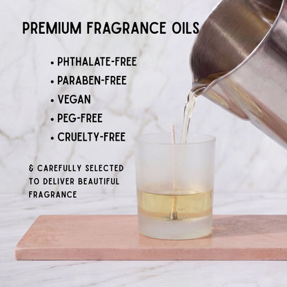 Premium candle fragrance oil being poured into a frosted glass candle jar, highlighting vegan, cruelty-free, PEG-free, paraben-free and phthalate-free fragrance oils.